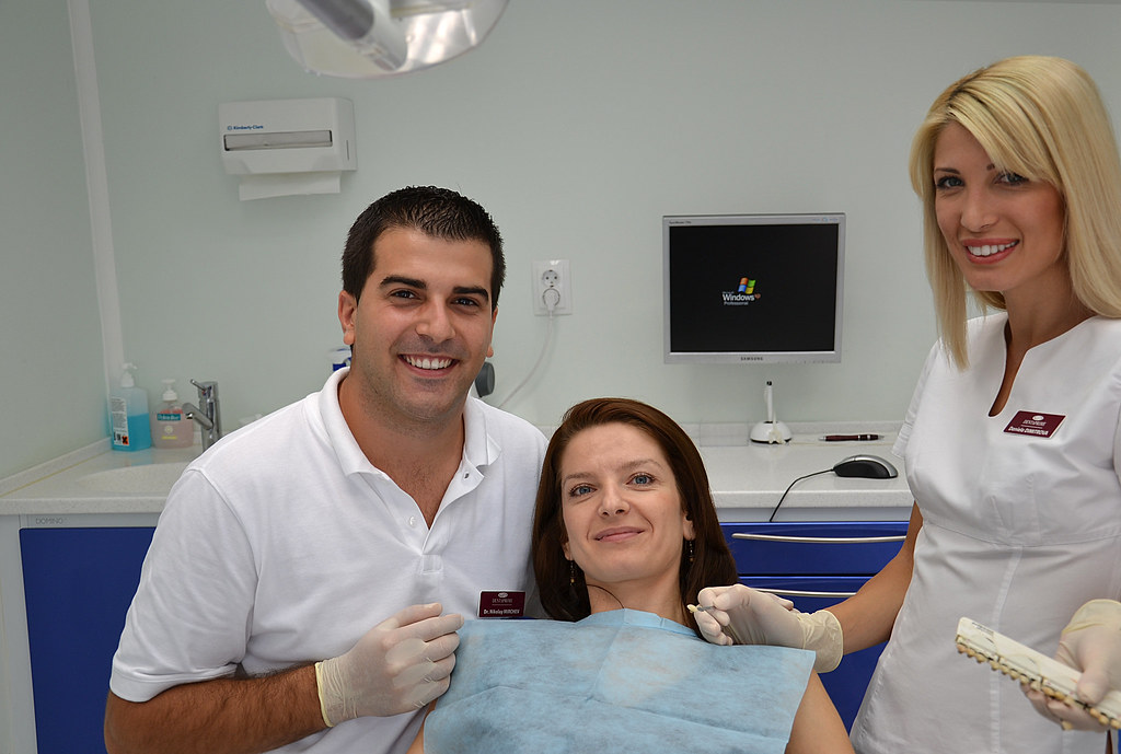 Dentist and dental assistant with a smiling patient in a California dental clinic