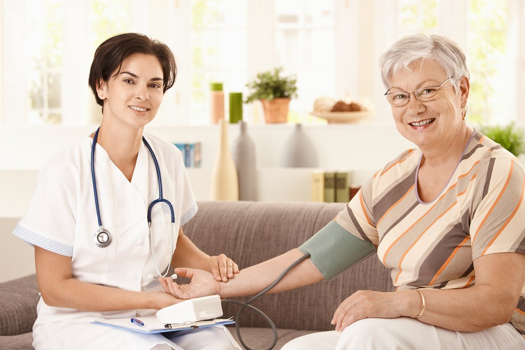 Registered nurse checking an older patient’s blood pressure at a community health center