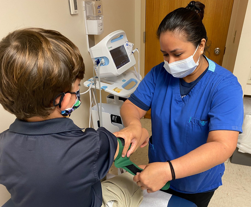 Clinician talking with a patient during an exam at a community health clinic in a staffing placement setting