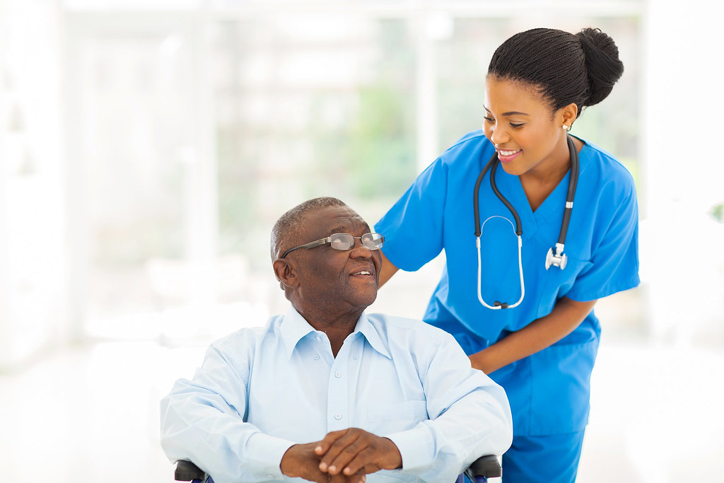 Nurse caring for an older patient in a wheelchair during recuperative care