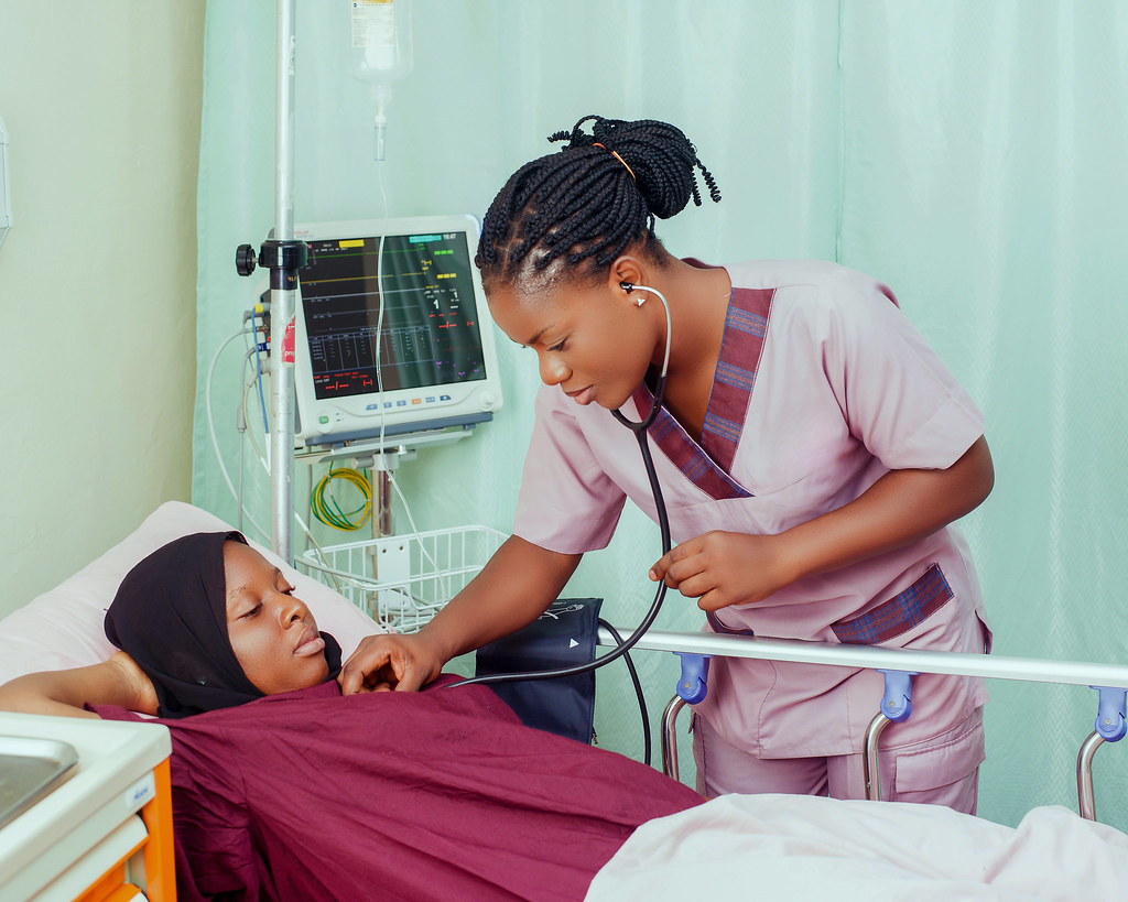 Travel nurse checking a patient's vitals at the bedside during a contract assignment