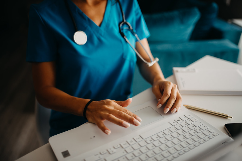 Nurse completing a California RN license application on a laptop