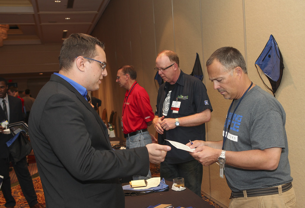 Recruiter accepting a candidate resume at a hiring event