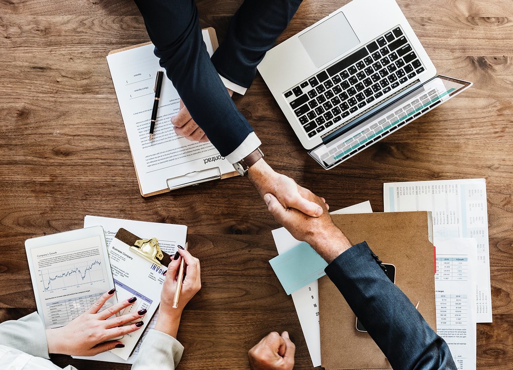 Hiring manager and clinician shaking hands over an offer letter at a community clinic